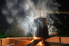 Vintage Enamel Kettle On The Wood-burning Stove In The Night .camping.antique Coffee Kettle. Bonfire In The Countryside.soft Focus.