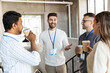 © Syda Productions - business, people and corporate concept - happy smiling colleagues with name tags drinking takeaway coffee at office