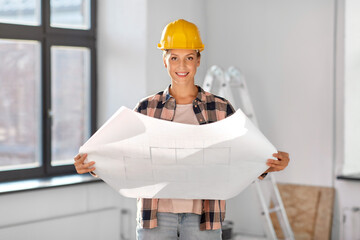 Wall Mural - repair, people and real estate concept - woman in helmet with blueprint sitting on floor at home