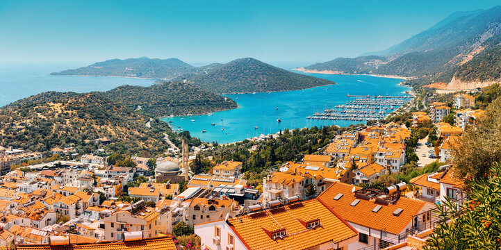 Majestic panoramic view of seaside resort city of Kas in Turkey. Romantic harbour with yachts and boats. Villas and hotels with red roofs are open for tourists