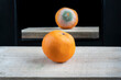 Fresh and ripe orange fruit on table against mirror reflection with rotten bad side. 