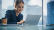 © Gorodenkoff - Close Up Portrait of a Successful Businesswoman Working on Laptop in Open Office with Colleague, Confident Female CEO Analyze Financial Projects. Manager at Work Planning Marketing Campaign.