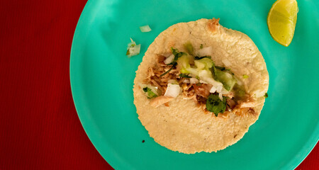 over head photo of two Mexican carnitas tacos on place in flat lay composition