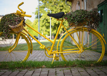 Yellow Bicycle With Flowers In The Green Grass