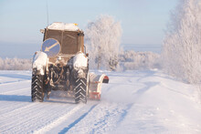 The Tractor Cleans The Road From Snow In Winter On A Frosty Fresh Day