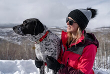 Smiling Woman Hiking With Dog During Winter Vacation