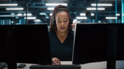 Fototapete - Call Center Office: Portrait of Friendly African American Female Technical Customer Support Specialist Talking on a Headset, uses Computer. Client Experience Officer Helps Online via Video Conference