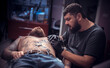 © Mr. Prof - Tattoo artist making tattoo in salon his salon