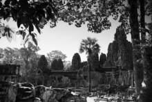 Grayscale Shot Of The Angkor Thom In Cambodia With Lush Greenery All Around It
