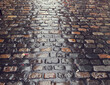 Wet cobble road surface after a rain. Old way pavement surface build to last for centuries.