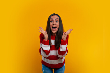 Wall Mural - Close up portrait of an excited attractive modern woman in a sweater while she is celebrating some win and shouting from happy