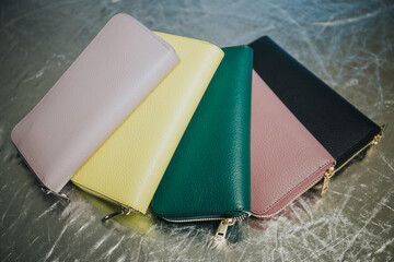 Closeup of colorful wallets placed close together on a silver surface