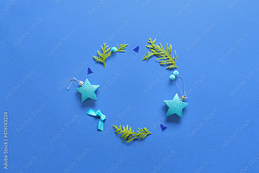 Frame made of fir branches and Christmas decor on blue background