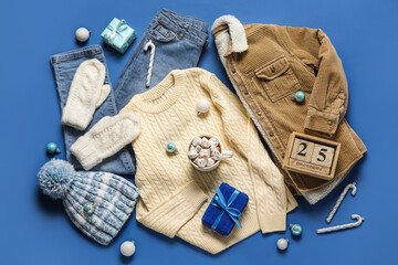 Set of children's clothes, cup of hot chocolate and calendar with date of Christmas on color background