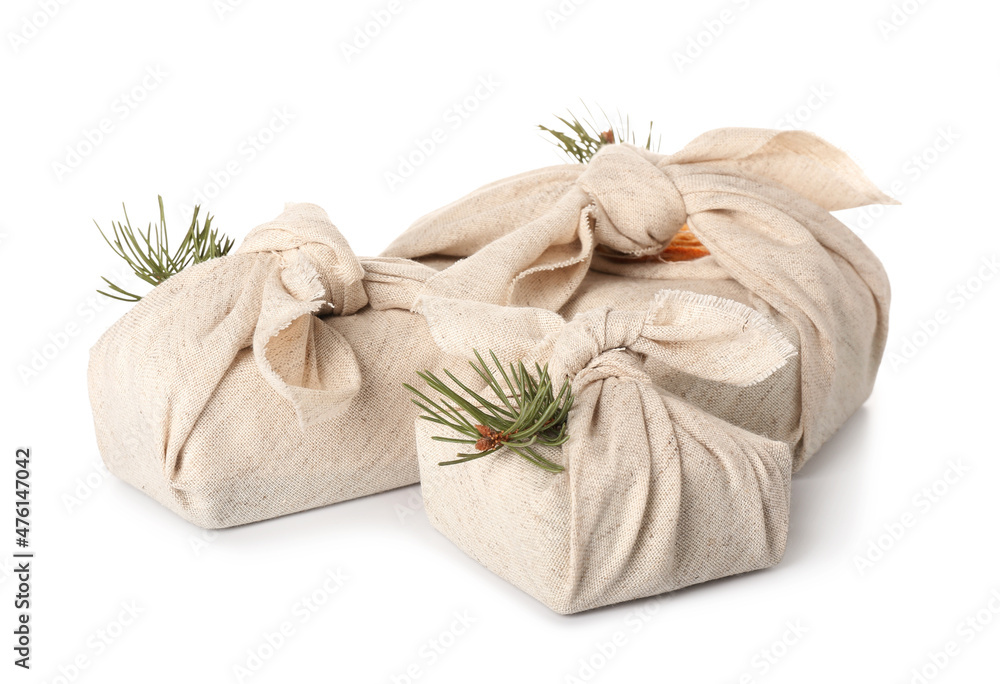 Christmas gifts wrapped in cloth on white background