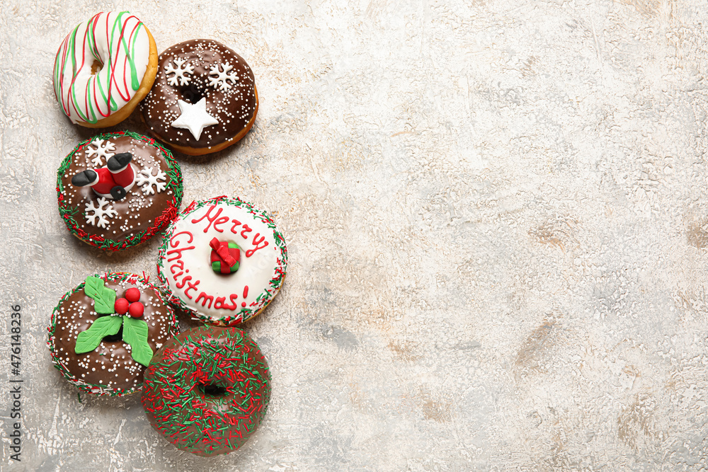Tasty Christmas donuts on light background