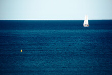 Maximizing Sea  Blue View With A Sailing  Boat In  Malta With A Light Sky On The Horizon