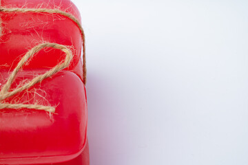 Red handmade soap bars tied with ribbon on white background