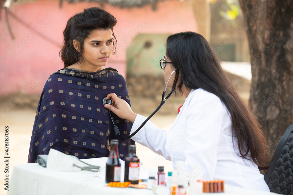 Indian female doctor check young adult girl patient heartbeat with ...