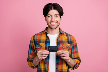 Poster - Photo of charismatic pretty young gentleman wear plaid outfit holding credit card smiling isolated pink color background