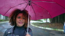 Brazilian Woman Holding Umbrella Walking Outside In City During Rain