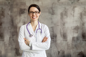 Portrait of a woman doctor with stetoscope looking at camera. Smiling female doctor in a clinic background.