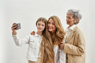 Wall Mural - Family of females taking selfie on smartphone