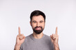 © Tetiana - Photo of young cheerful guy point fingers empty space advert promotion suggest isolated over grey color background