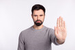 © Tetiana - Photo of young man sho hand no stop refuse rejection symbol avoid block isolated over grey color background