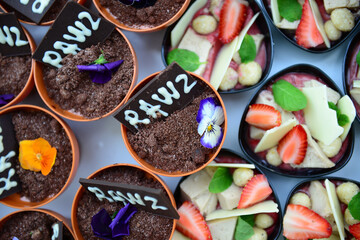 Poster - Top view of tasty sweet desserts assortment decorated with fruits and flowers served for the event