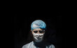 doctor surgeon in uniform in dark operating room, concept of criminal surgery and illegal internal organ transplantation.
