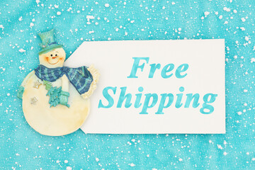 Wall Mural - Free Shipping message on white gift tag with snowman on blue