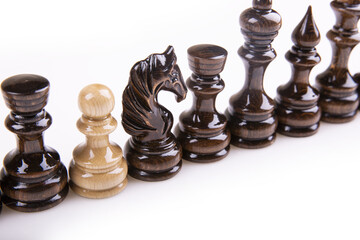 Canvas Print - Single pawn in the same row with black chess pieces - the concept of an enemy and liar in a group