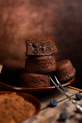 Poster - Vertical shot of a stack of chocolate muffins on a brown plate