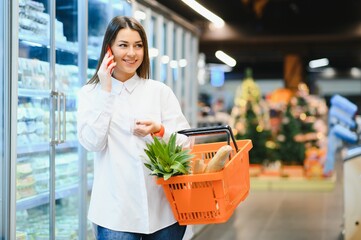 Wall Mural - Casual woman grocery shopping and looking happy