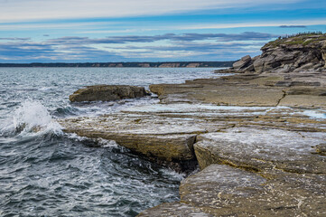 Wall Mural - the rugged shoreline of the St Lawrence estuary, with rocky formations sculpted by erosion near Cap Ferré waterfall in Havre St Pierre, in Cote Nord region of Quebec, Canada