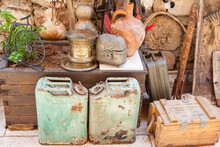 A Group Of Old Canisters, Cylinders And Some Other Tings Stand On Shelves In A Wooden Shed