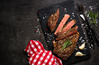 Beef steak on black background with spices. Grilled beef steak striploin medium rare on slate serving board. Top view with copy space.
