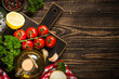 Food cooking background at wooden kitchen table. Fresh vegetables, spices, herbs and oil. Flat lay image with copy space.