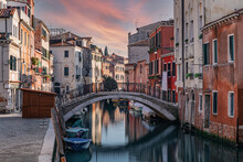 Scenery Of A Channel Surrounded By Buildings Of Venice In Italy At Sunset