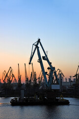 Wall Mural - Floating cargo crane at sunset