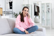 © BestForYou - Feminine gossip while relaxing on couch at home.