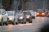 Fototapeta Kwiaty - Traffic jam with many cars moving slowly on city street at night. Urban transportation concept