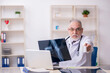 © Elnur - Old male doctor radiologist working in the clinic
