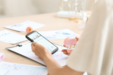 Poster - Female wedding planner with phone working in office, closeup