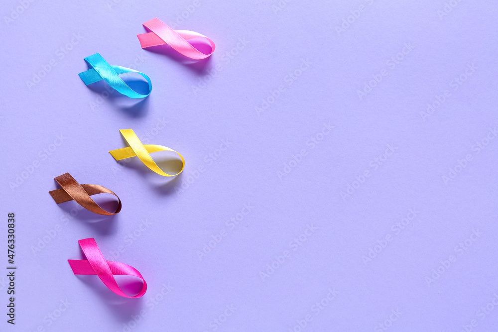 Colorful awareness ribbons on lilac background. World Cancer Day