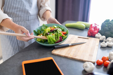 Wall Mural - Woman cutting vegetables on a cutting board