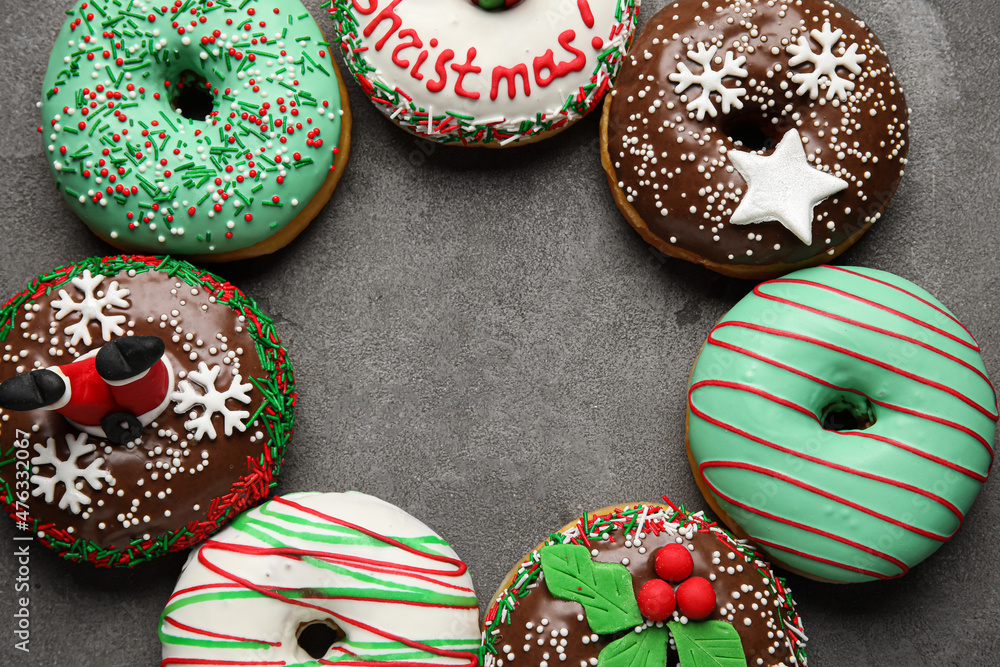 Frame made with tasty Christmas donuts on grey background