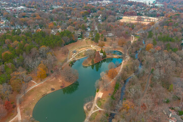 a stunning aerial shot of the silky green lake water in the park surrounded by gorgeous green and autumn colored trees at Freedom Park in Charlotte North Carolina USA