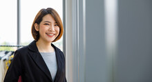 Portrait Close Up Studio Shot Of Asian Young Happy Short Hair Female Cheerful Millennial Businesswoman Blogger Vlogger Freelancer Influencer In Formal Suit Smiling Look At Camera In Office Building